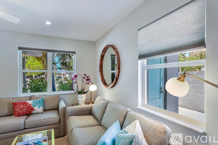 A living room with a couch, a coffee table, and a mirror on the wall.