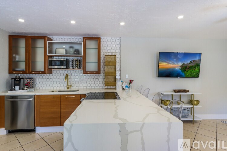 A kitchen with a white countertop and wooden cabinets.