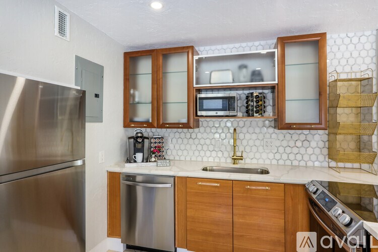 A kitchen with wooden cabinets and a stainless steel refrigerator.