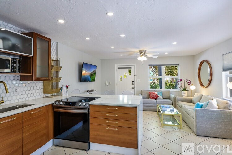 A modern kitchen with wooden cabinets and a black stove top oven.