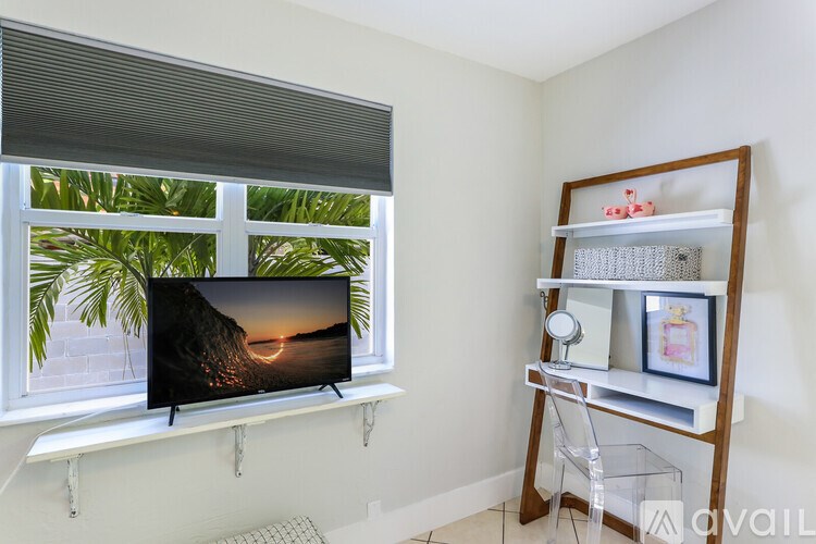 A flat screen TV is on a stand in front of a window.