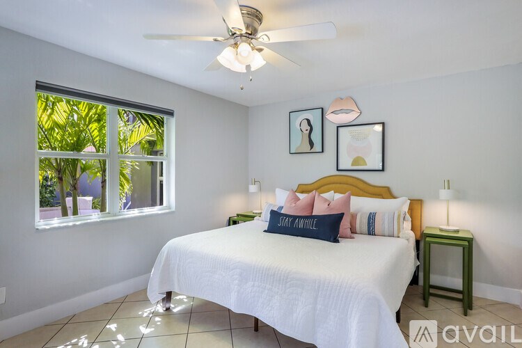 A bedroom with a bed, a window, and a ceiling fan.