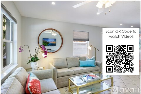 A living room with a couch, coffee table, and a painting on the wall.