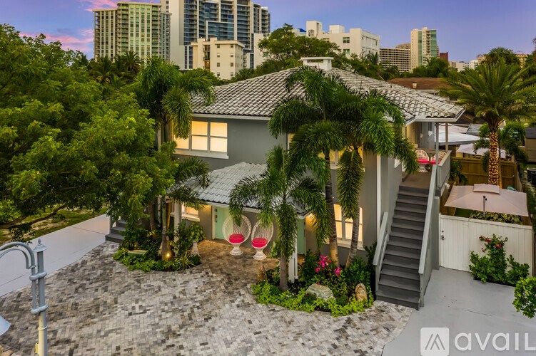 A house with a patio and a staircase leading to a balcony.