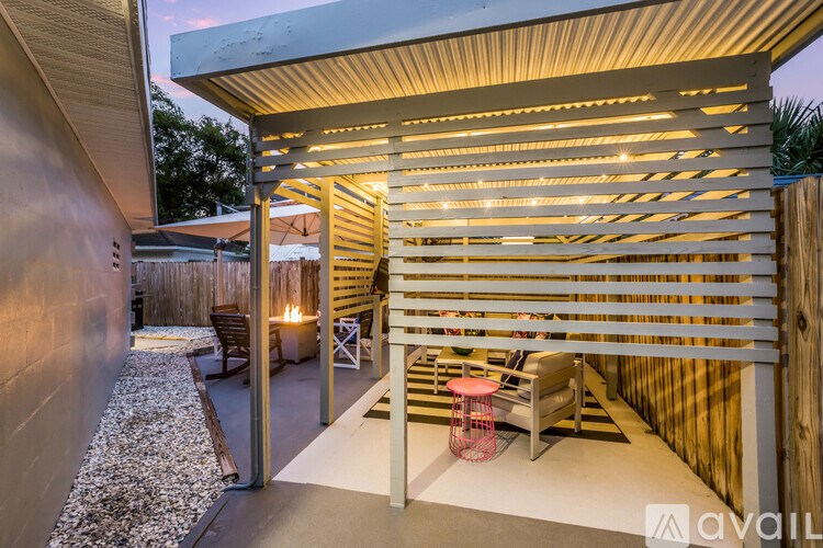 A patio area with a wooden pergola and a fire pit.