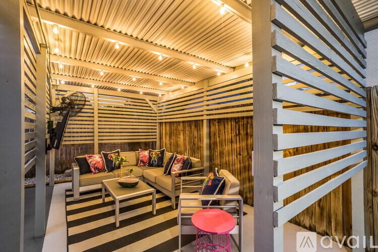 A modern living room with a striped wall and a wooden ceiling.