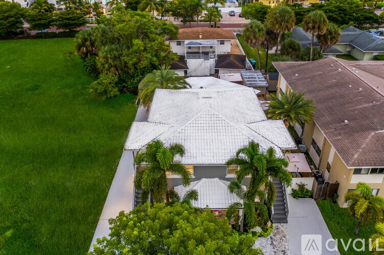 A house with a white roof surrounded by greenery.