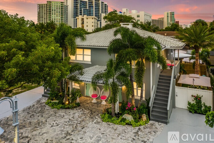 A house with a patio and a staircase leading to a balcony.