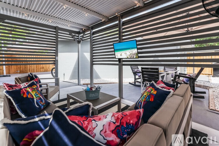 A living room with a couch, chairs, and a television.