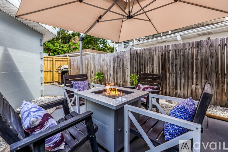 A patio with a table, chairs, and an umbrella.