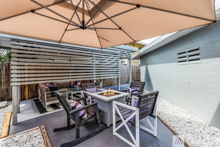 A patio with a table and chairs under an umbrella.
