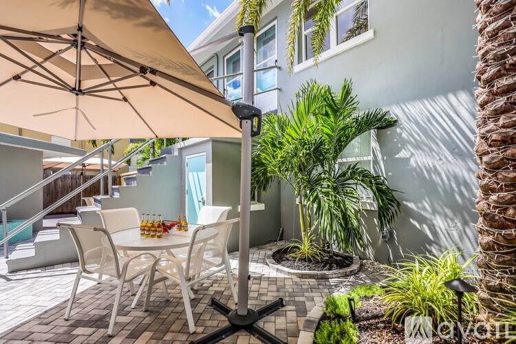 A patio with a table and chairs under an umbrella.