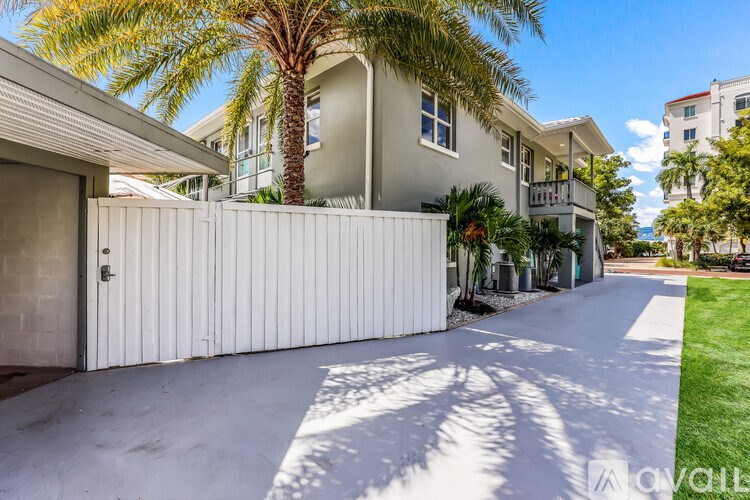 A modern house with a white garage door and a palm tree in front.