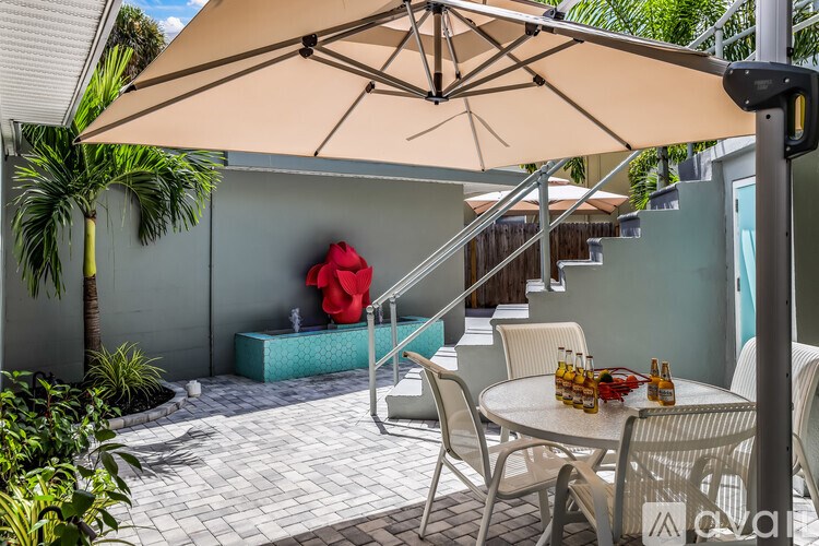 A patio with a table, chairs, and an umbrella.