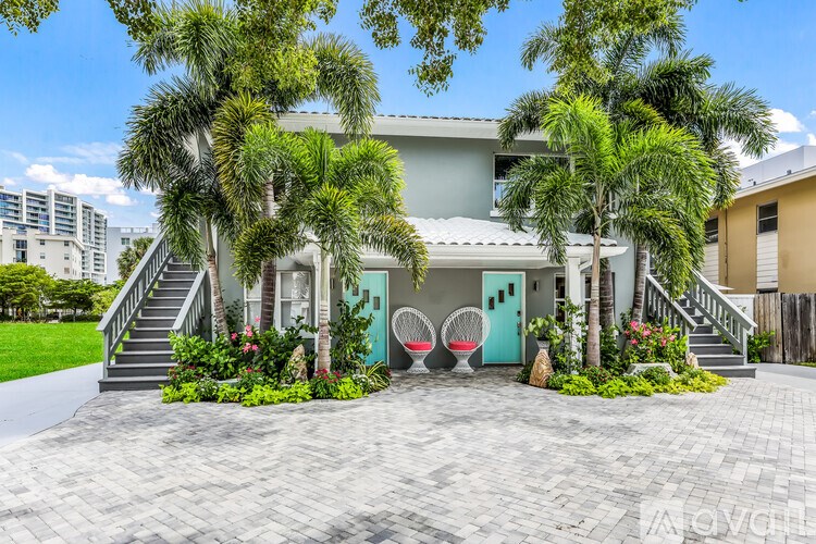 A house with a green door and a red chair in front of it.