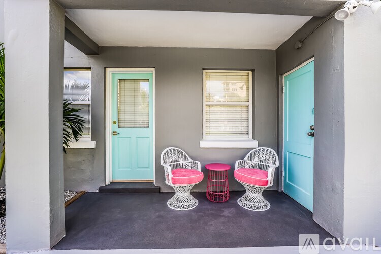 A patio with two chairs and two tables.