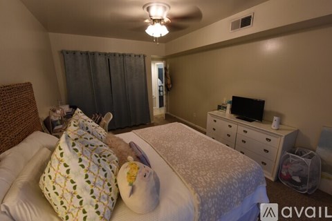 A bedroom with a bed, nightstand, and chair.