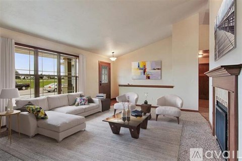 A living room with a white couch, a coffee table, and a painting on the wall.