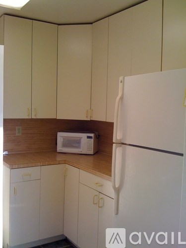 A kitchen with white cabinets and a white refrigerator.