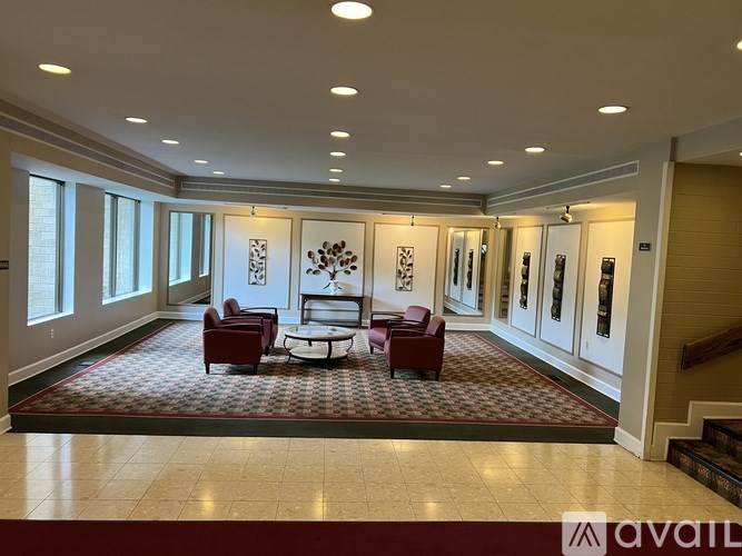 A spacious room with a red carpet and a sofa set.