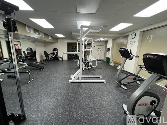 A gym with a variety of equipment including treadmills, weights, and exercise machines.