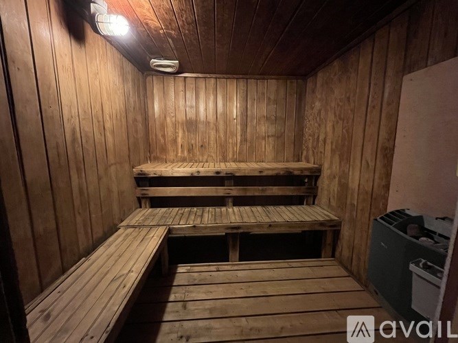 A wooden sauna room with benches and a door.
