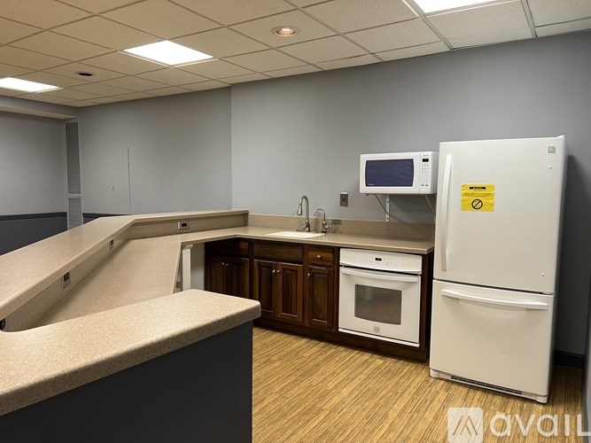 A kitchen with a refrigerator, microwave, and oven.
