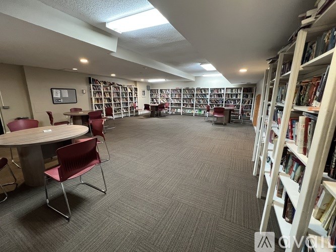 A library with bookshelves, tables, and chairs.