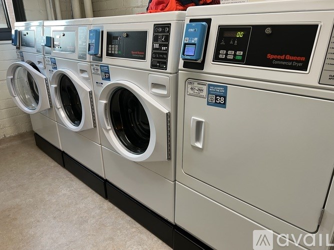 A row of Speed Queen washing machines are lined up in a row.