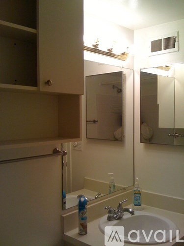 A bathroom with a sink, mirror, and a cabinet.