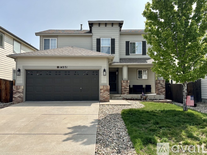 A two-story house with a garage and a driveway.