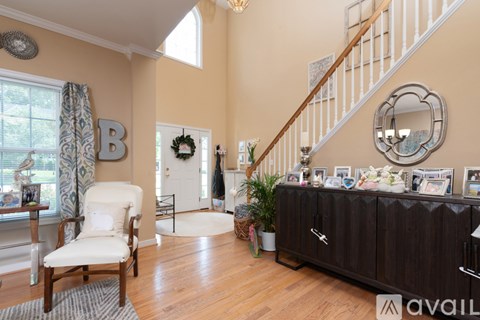 A living room with a white chair and a brown cabinet.