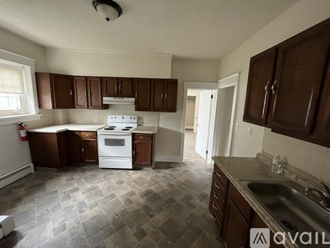 A kitchen with white appliances and brown cabinets.