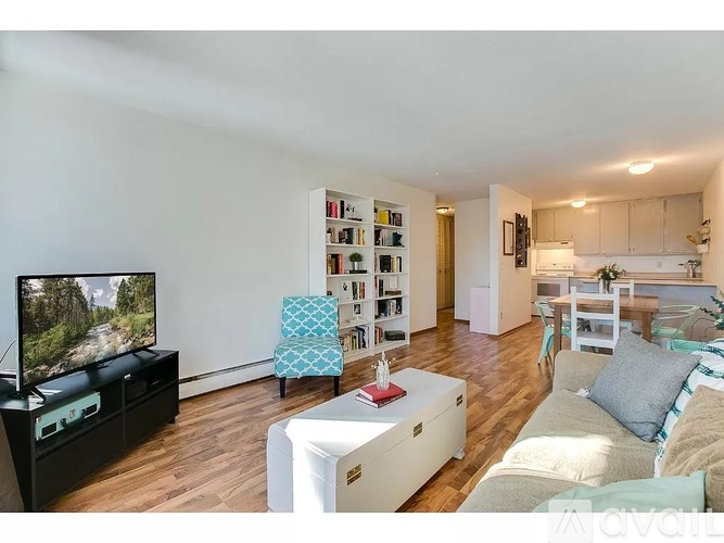 A living room with a television, a chair, a bookshelf, and a couch.