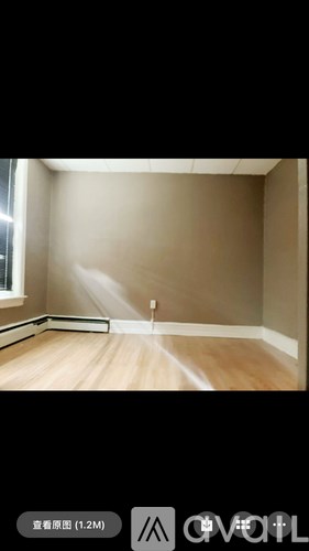 A room with wooden flooring and a white wall.