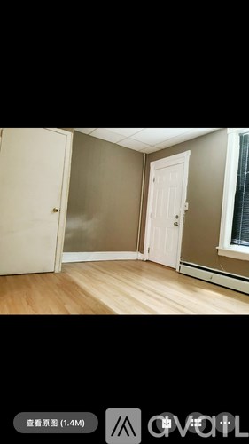 A room with a white door and a window with a curtain.