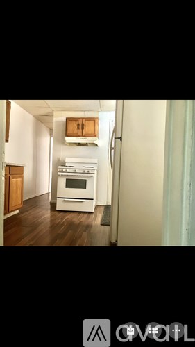 A kitchen with a white oven and wooden cabinets.