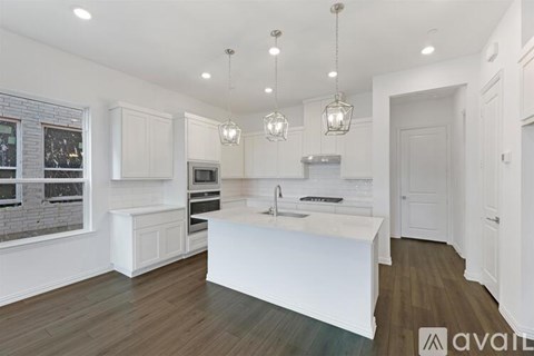 A modern kitchen with white cabinets and a central island.