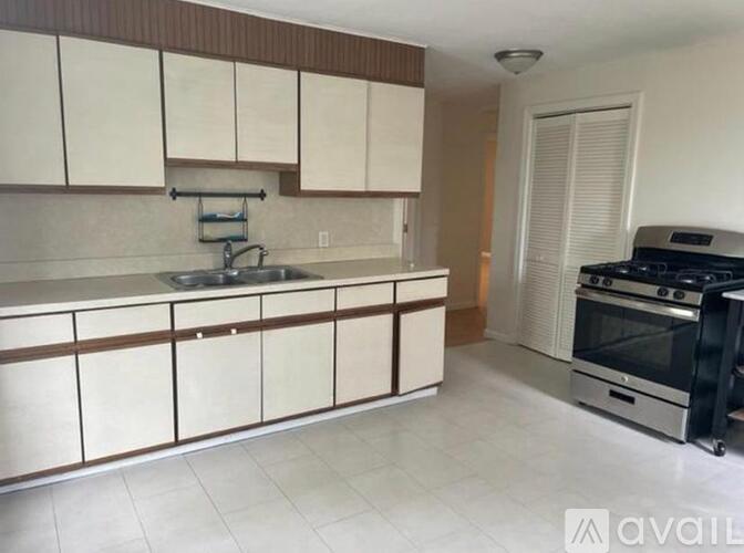 A kitchen with white cabinets and a black stove top oven.