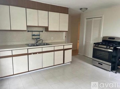 A kitchen with white cabinets and a black stove top oven.