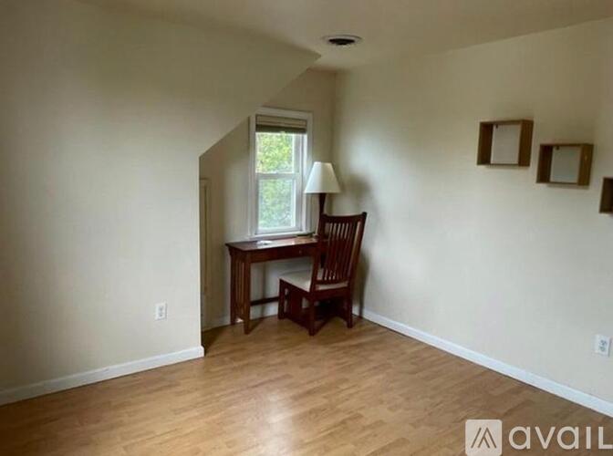 A room with a desk and chair in it.