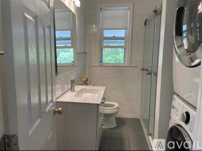 A small bathroom with a toilet, sink, and window.