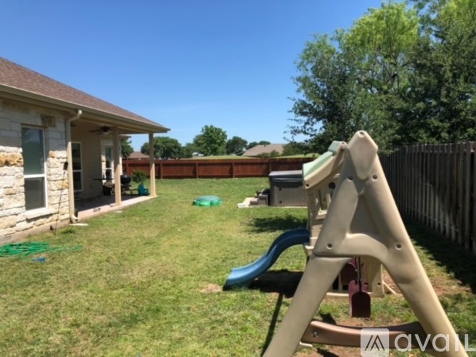 A playground with a slide and a wooden fence.