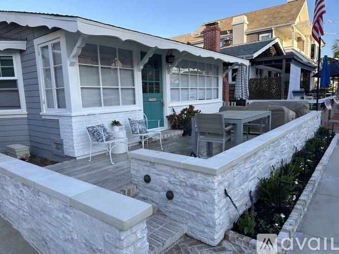 A patio with a white wall and a blue door.