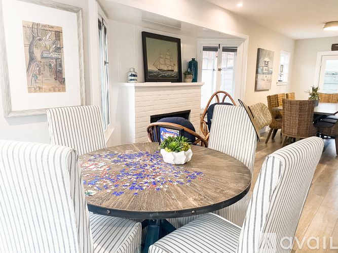 A dining room with a wooden table surrounded by striped chairs.