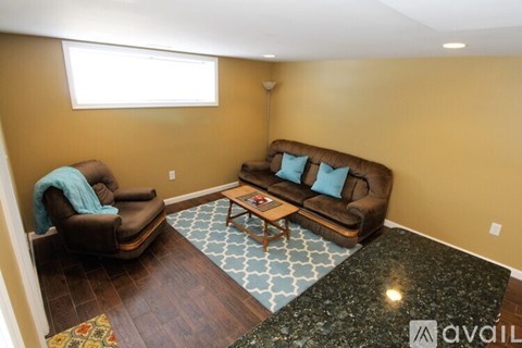 A living room with a brown couch, a chair, and a coffee table.