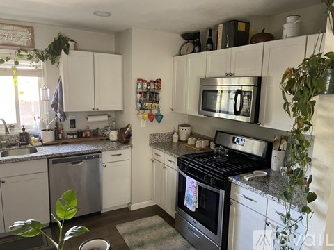 A kitchen with a black stove top oven and a microwave above it.