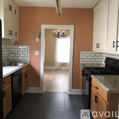 A kitchen with orange walls and wooden cabinets.