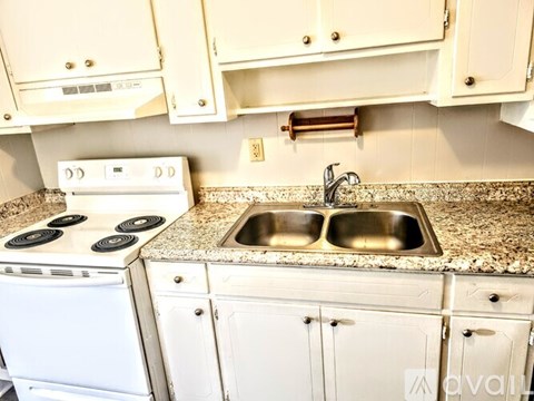 A kitchen with a white oven and sink.