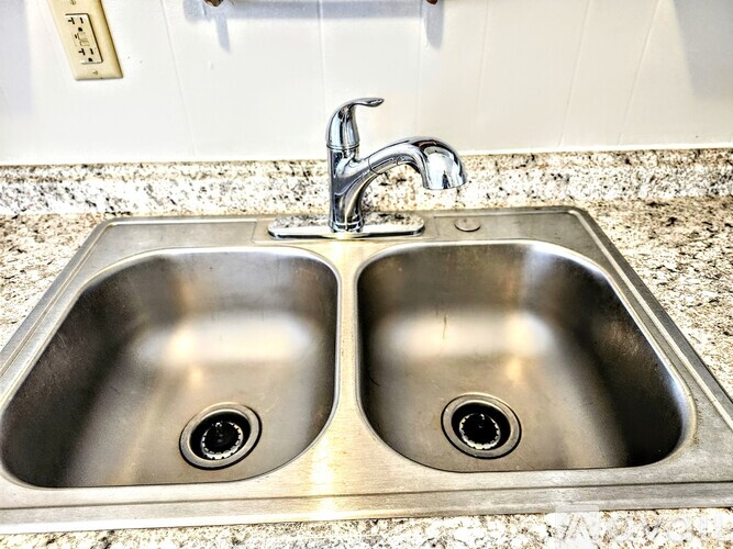 A double sink in a bathroom with a silver faucet.